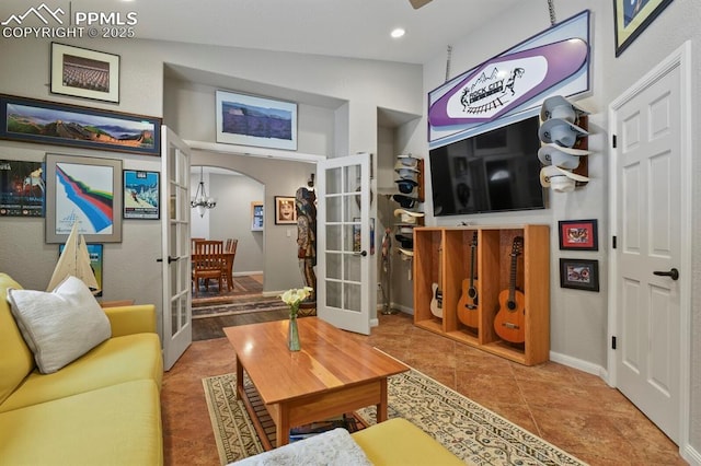 living room with arched walkways, baseboards, vaulted ceiling, french doors, and tile patterned floors