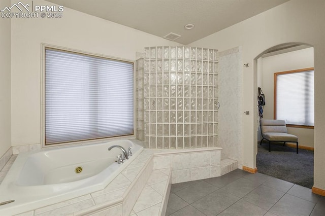 full bath with visible vents, tile patterned floors, a whirlpool tub, vaulted ceiling, and a walk in shower