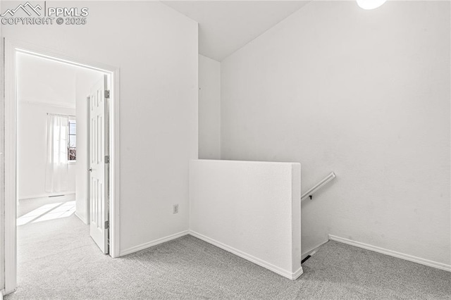 hallway featuring light carpet and lofted ceiling