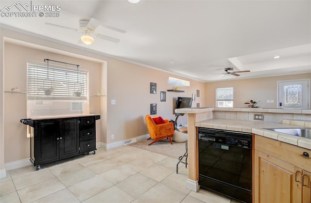 kitchen with dishwasher, tile countertops, light brown cabinetry, and baseboards