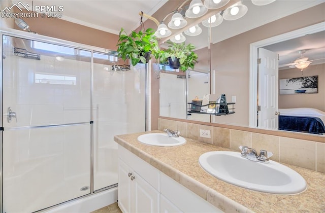 bathroom featuring a shower stall, tasteful backsplash, a sink, and crown molding