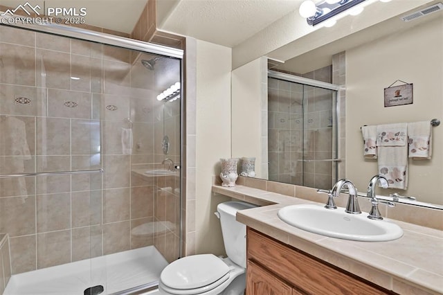 bathroom featuring an enclosed shower, vanity, and toilet