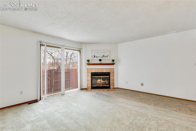 unfurnished living room with a tiled fireplace, light carpet, and a textured ceiling