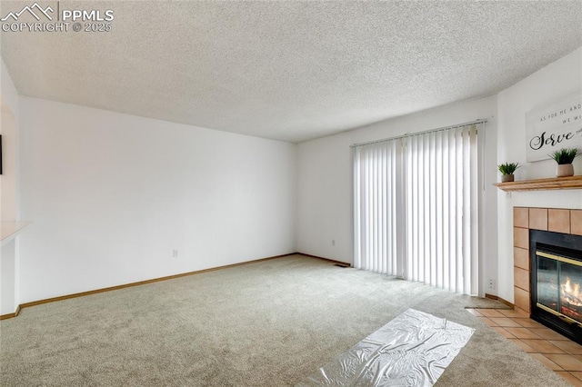 unfurnished living room with light colored carpet, a tile fireplace, and a textured ceiling