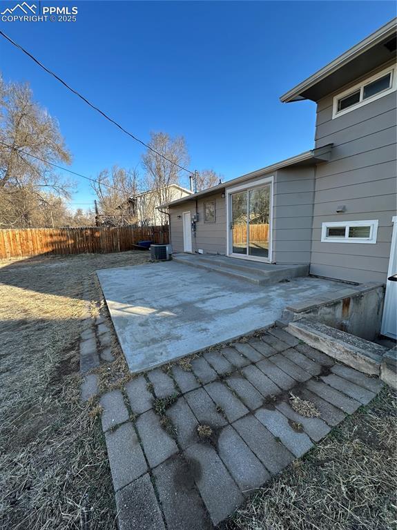 rear view of property featuring a patio area and fence