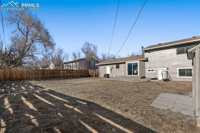 rear view of house with central AC, a patio area, and a fenced backyard