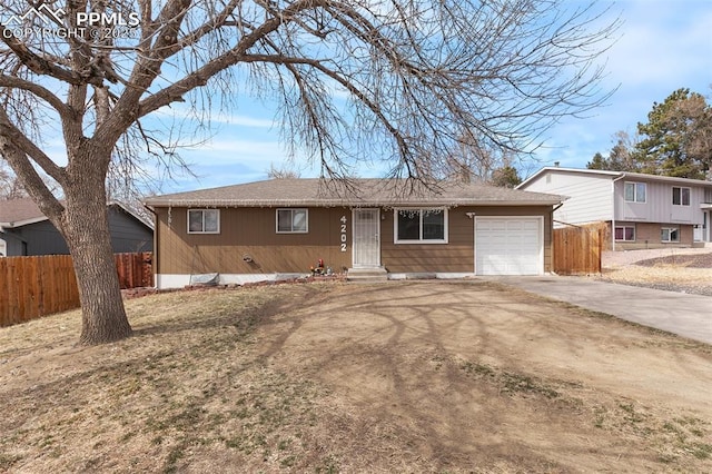 ranch-style house featuring driveway, a garage, and fence