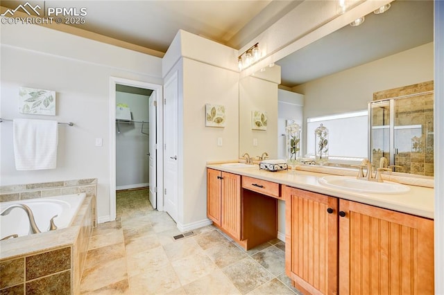 full bath featuring a garden tub, double vanity, a sink, and a shower stall