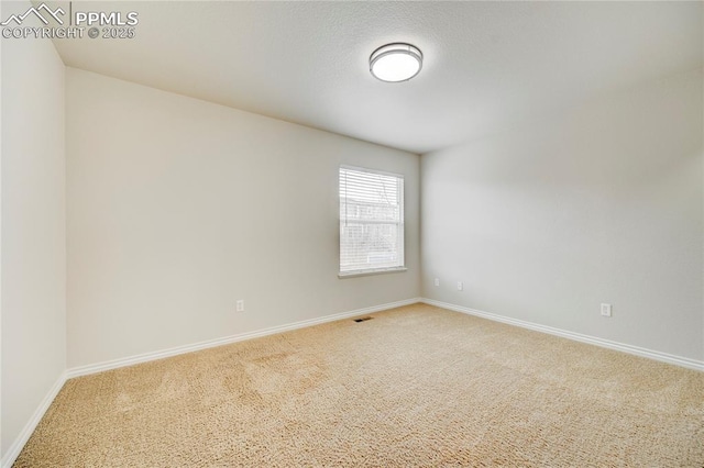 carpeted spare room featuring visible vents and baseboards