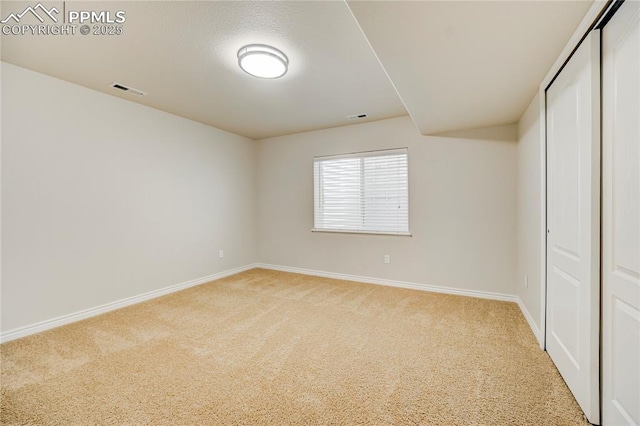 unfurnished bedroom featuring light carpet, baseboards, visible vents, and a closet