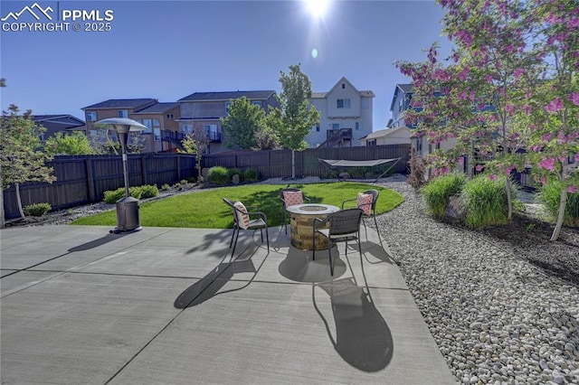 view of patio featuring an outdoor fire pit, a residential view, and a fenced backyard