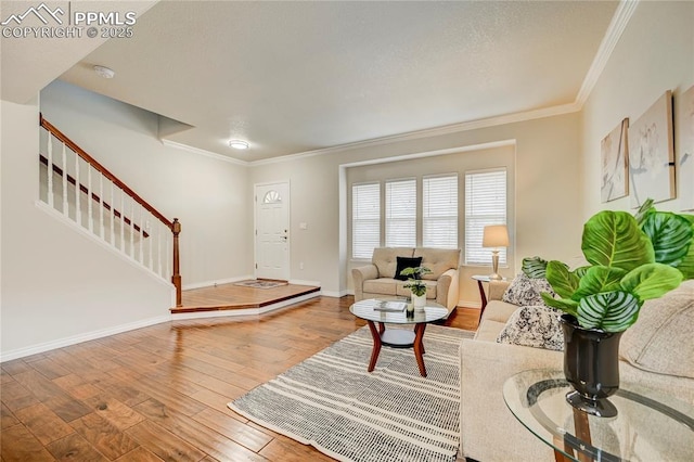 living room with wood-type flooring, stairway, baseboards, and ornamental molding