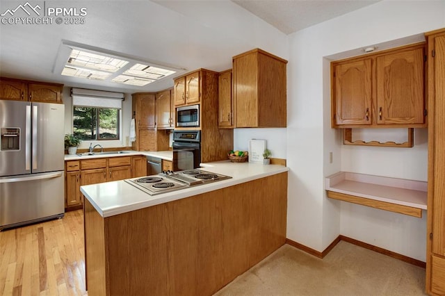 kitchen with light countertops, appliances with stainless steel finishes, brown cabinetry, a peninsula, and baseboards