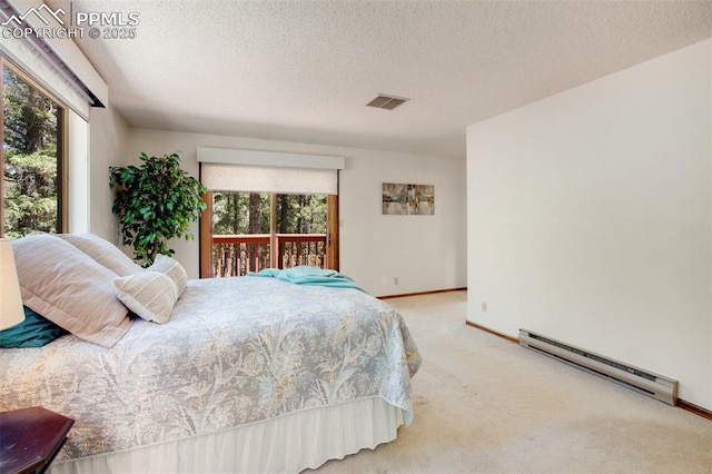 bedroom with a textured ceiling, light colored carpet, visible vents, baseboards, and baseboard heating