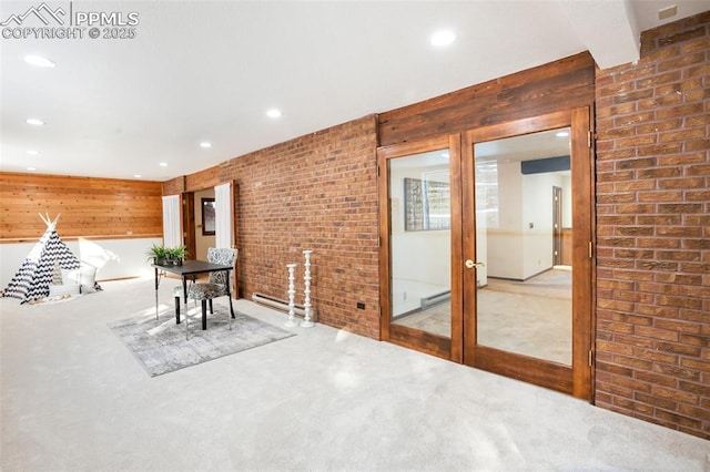 unfurnished dining area featuring a baseboard heating unit, brick wall, carpet flooring, and recessed lighting