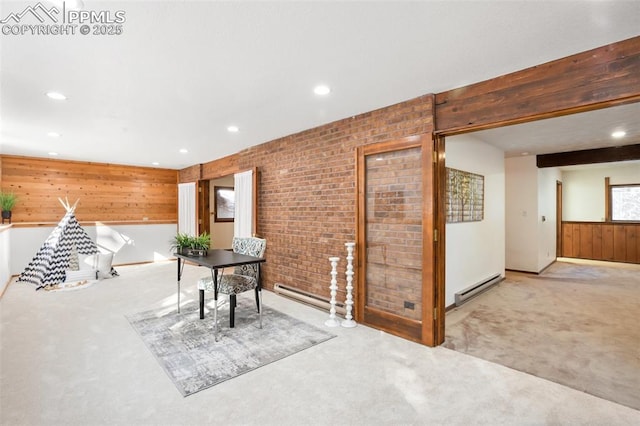 interior space featuring brick wall, baseboard heating, beamed ceiling, and light colored carpet