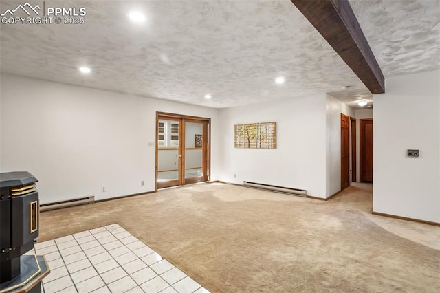 unfurnished living room with a wood stove, baseboards, baseboard heating, and light colored carpet