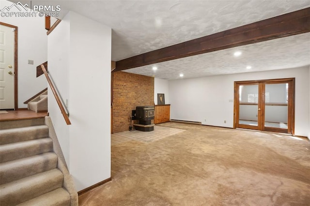 below grade area featuring french doors, a baseboard heating unit, a wood stove, carpet flooring, and stairs