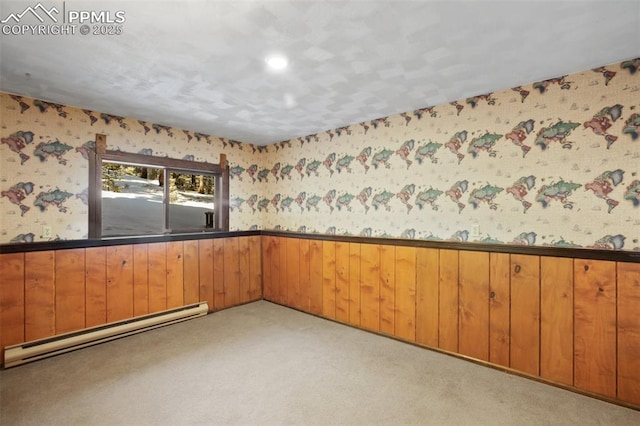 spare room featuring a baseboard radiator, a wainscoted wall, light carpet, and wallpapered walls