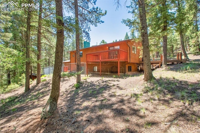 rear view of house featuring a wooden deck