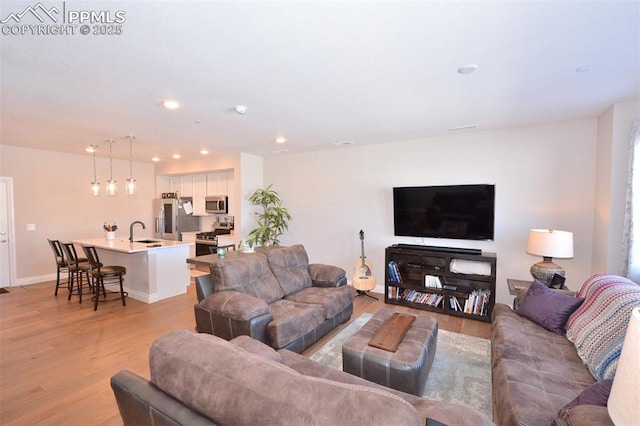 living room with sink and light hardwood / wood-style floors