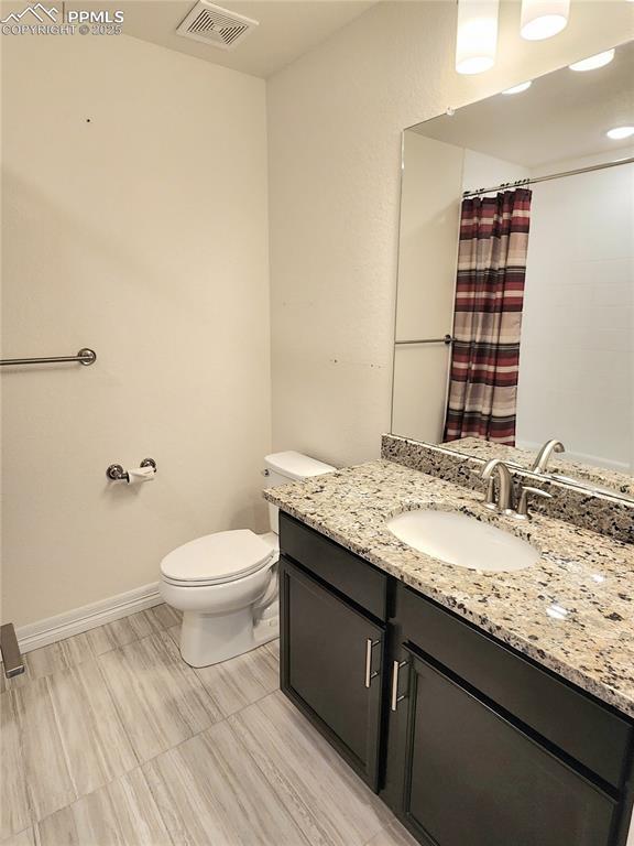 full bath featuring baseboards, visible vents, toilet, curtained shower, and vanity