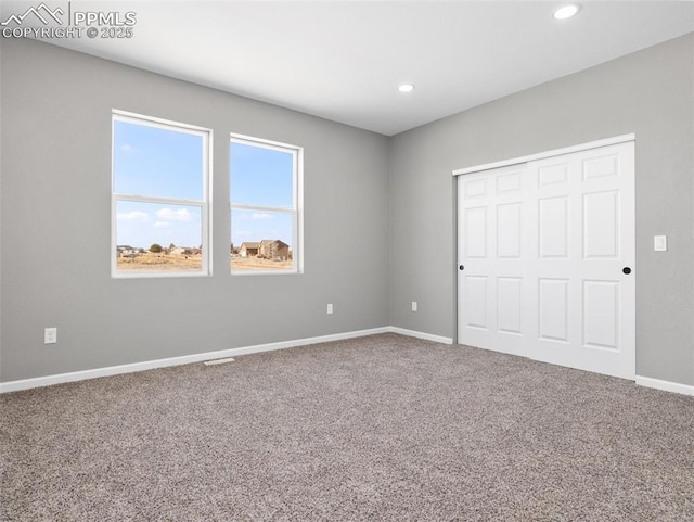 unfurnished bedroom featuring carpet flooring, baseboards, a closet, and recessed lighting