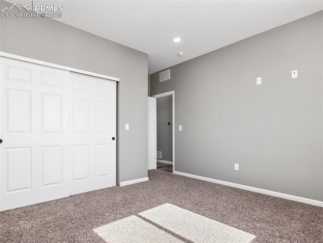 unfurnished bedroom with visible vents, a closet, baseboards, and carpet floors