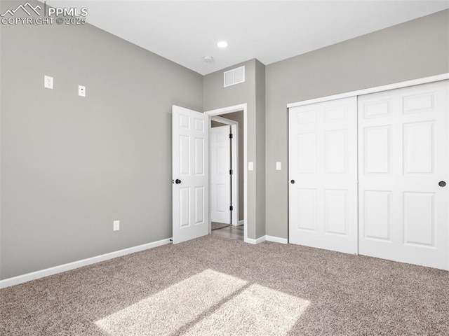 unfurnished bedroom featuring carpet floors, a closet, baseboards, and visible vents