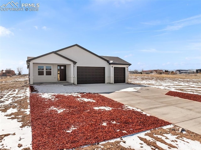 view of front of property with stucco siding, driveway, and a garage