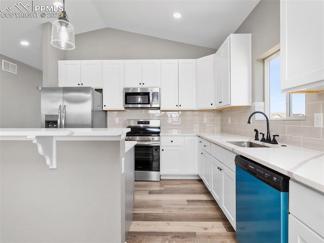 kitchen with stainless steel appliances, visible vents, white cabinets, and a sink