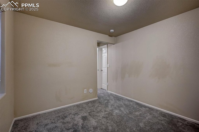 spare room featuring a textured ceiling and dark carpet