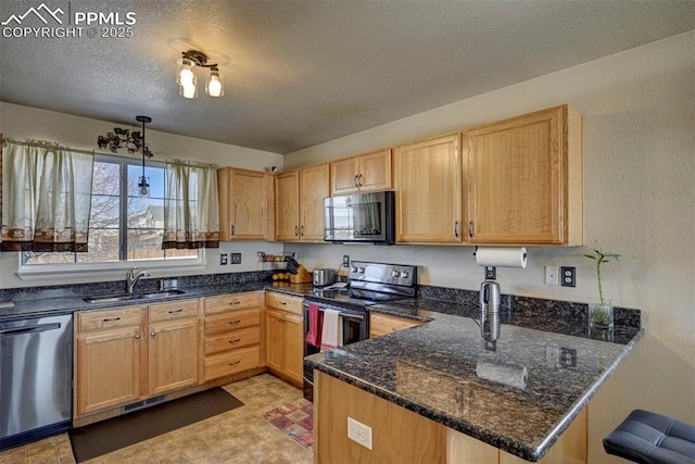 kitchen featuring sink, stainless steel appliances, decorative light fixtures, kitchen peninsula, and dark stone counters