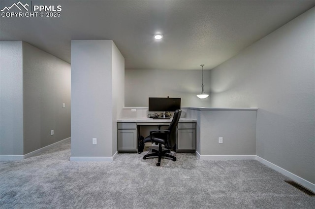 home office featuring light colored carpet, visible vents, and baseboards