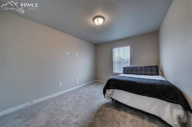 bedroom featuring carpet flooring, a textured ceiling, and baseboards