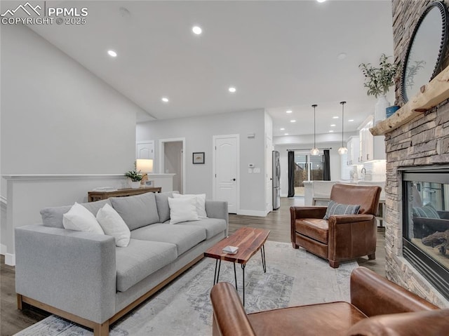 living room featuring hardwood / wood-style floors and a stone fireplace