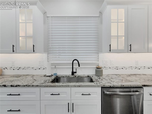 kitchen with white cabinets, dishwasher, light stone countertops, and sink