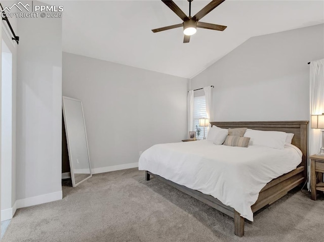 bedroom featuring ceiling fan, a barn door, vaulted ceiling, and light colored carpet