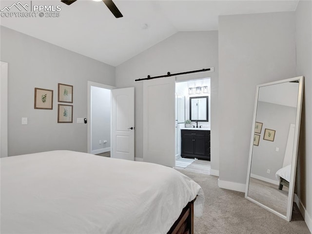 carpeted bedroom with ceiling fan, a barn door, connected bathroom, and lofted ceiling