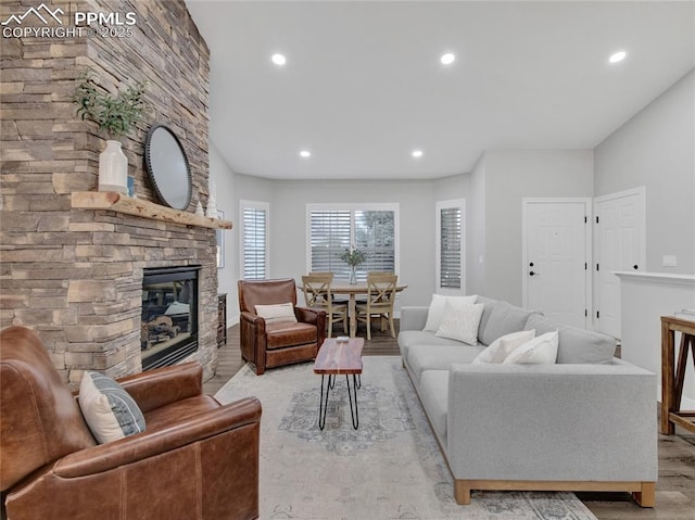 living room with light wood-type flooring and a stone fireplace