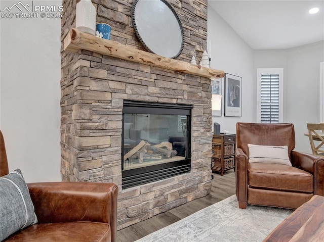 sitting room featuring hardwood / wood-style flooring and a stone fireplace