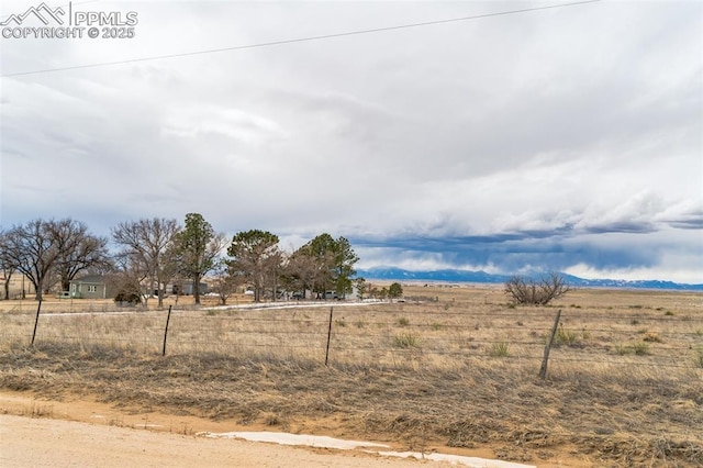 view of yard featuring a rural view and fence