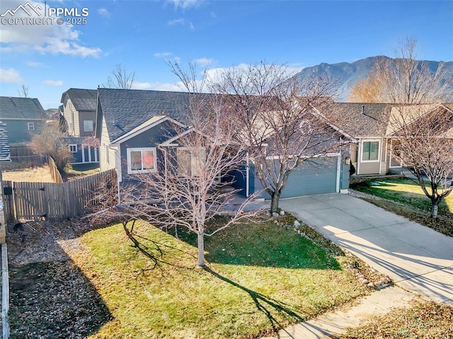 view of front of house with a garage, a shingled roof, fence, concrete driveway, and a front yard