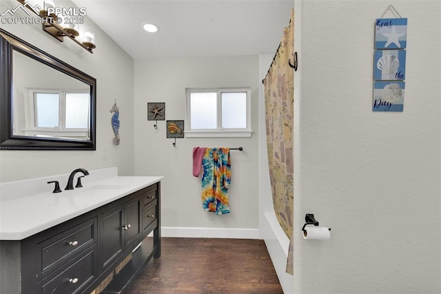 full bath featuring recessed lighting, wood finished floors, vanity, and baseboards