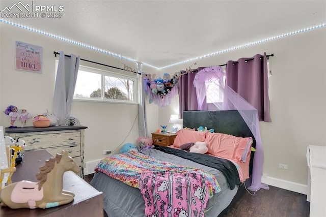 bedroom featuring wood finished floors and baseboards