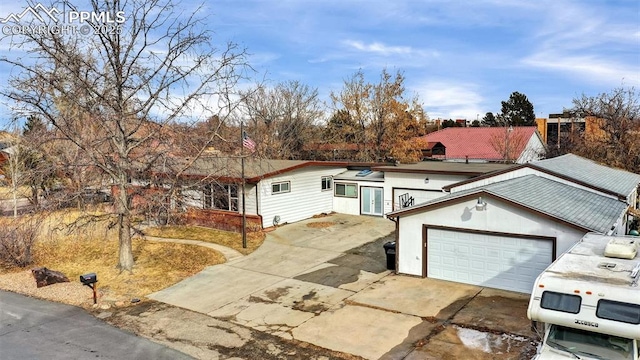 ranch-style house with a garage and driveway