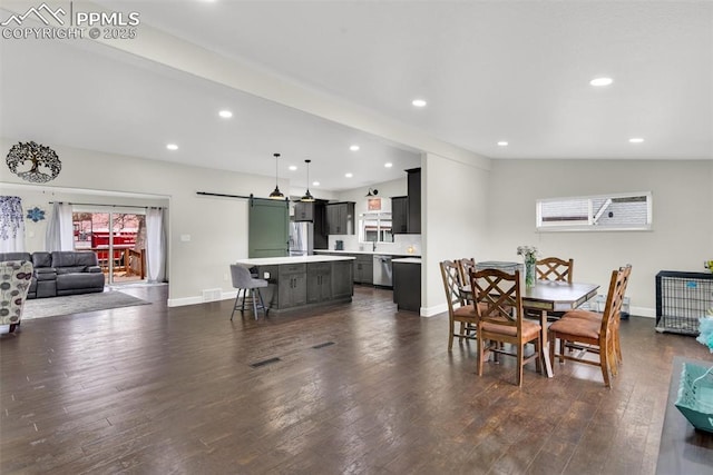 dining area with lofted ceiling, a barn door, baseboards, and dark wood finished floors