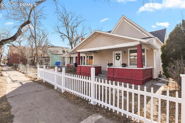 bungalow featuring a porch and a fenced front yard