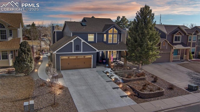 view of front facade featuring a shingled roof, a residential view, and concrete driveway