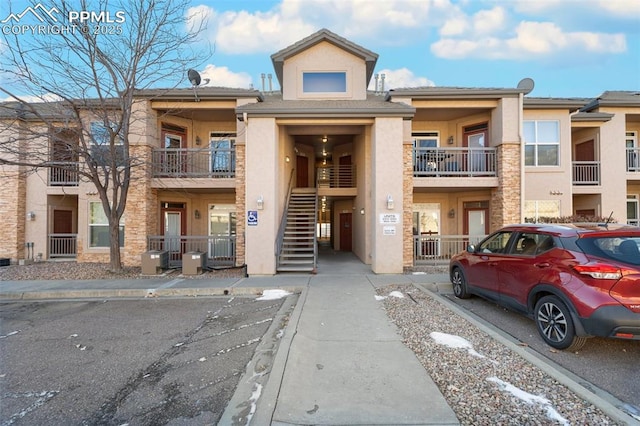 view of building exterior featuring stairs and central AC unit